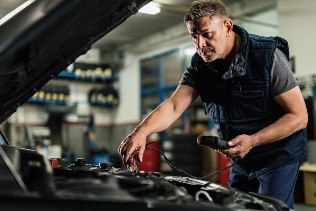 mecanicien-d-age-moyen-utilisant-un-outil-de-diagnostic-tout-en-verifiant-la-tension-d-une-batterie-de-voiture-dans-un-atelier-de-reparation-automobile-1024x683 Stereo Short Circuit Car Electrical Dies While Driving – What You Need to Know