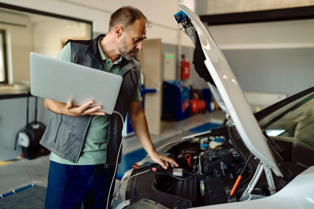 reparateur-automobile-utilisant-un-ordinateur-portable-lors-de-l-examen-d-un-moteur-de-voiture-dans-un-atelier-1024x683 Car Electrical Diagnostic Near Me | Fast & Accurate Service